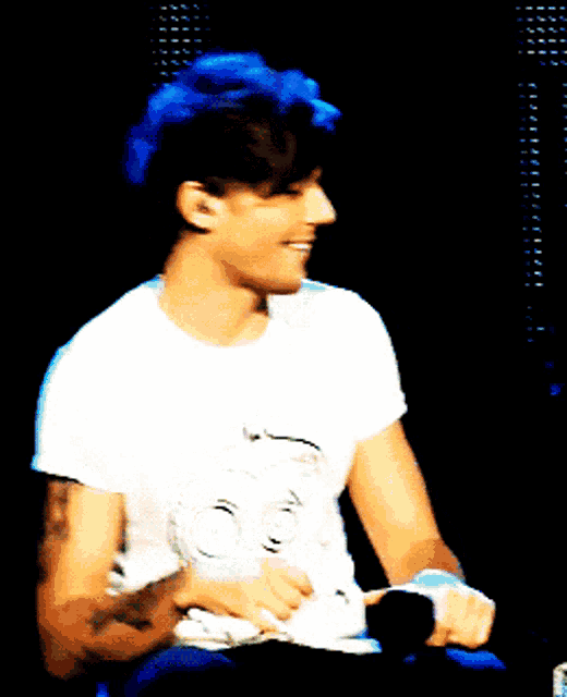 a man with a tattoo on his arm is wearing a white shirt with a skull on it