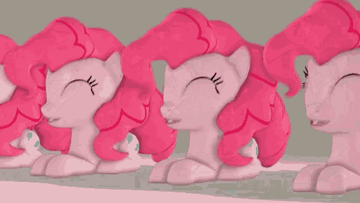 three pink ponies are sitting next to each other on a table .