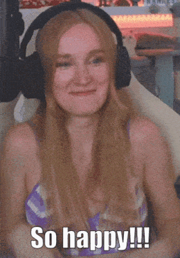 a woman wearing headphones and a purple top says so happy