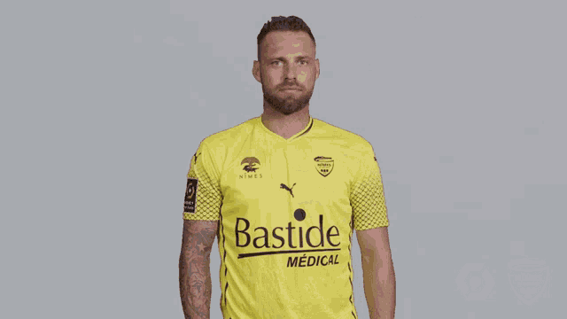 a man is wearing a yellow bastide medical shirt