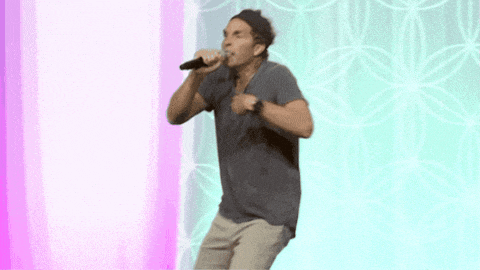 a man singing into a microphone while dancing