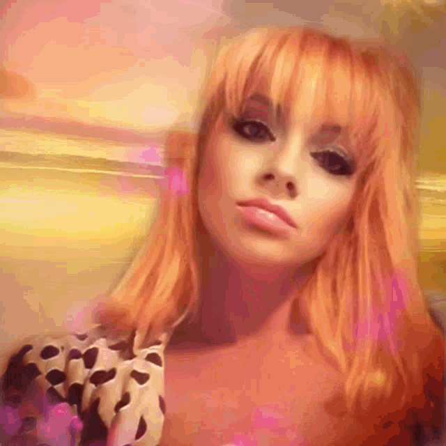 a woman with bright orange hair is wearing a polka dot dress