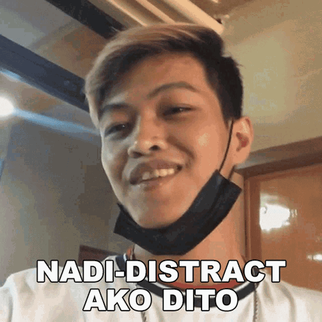 a young man wearing a face mask is smiling and says " nadi-distract ako dito "