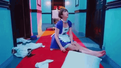 a woman in a maid costume is sitting on the floor .