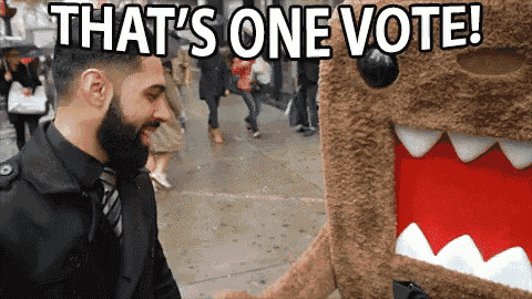 a man standing next to a stuffed animal with the words that 's one vote written on it