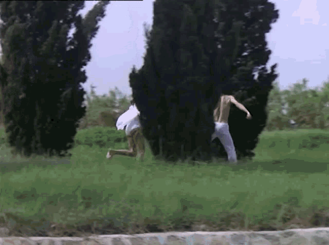 a man and a woman are running in a grassy field