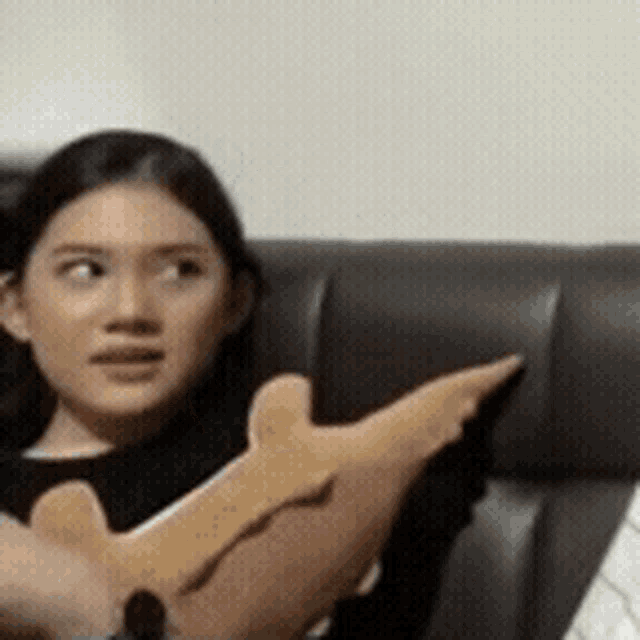 a woman is sitting on a couch holding a stuffed animal in her lap .