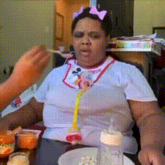 a woman sitting at a table with a bottle and a pacifier