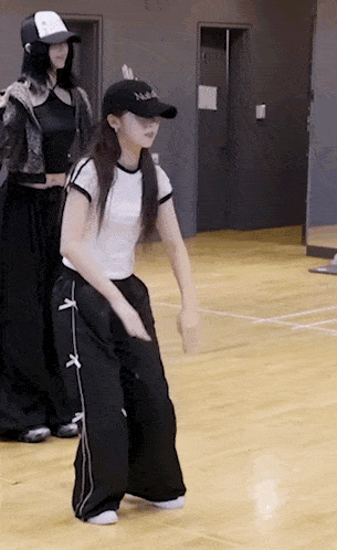 a woman is dancing on a wooden floor in a dance studio .