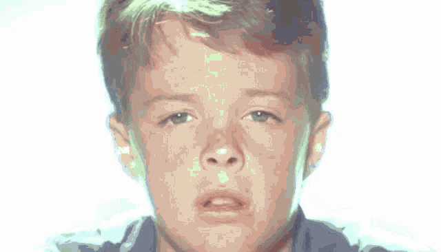 a young boy with his eyes closed and a serious look on his face