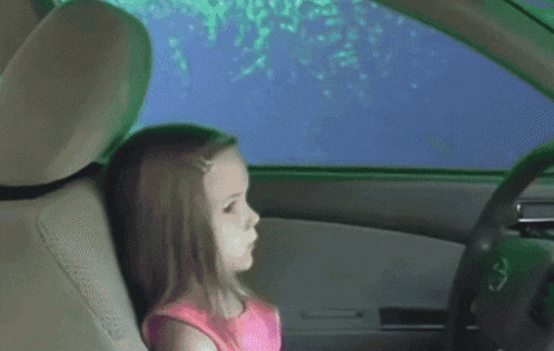 a person sitting in a car with their feet on a pink item
