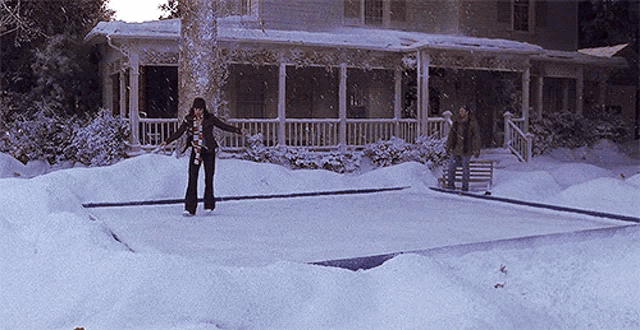 a woman is ice skating on a rink in front of a house