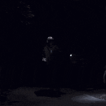 a man is standing in the dark with smoke coming out of his hat
