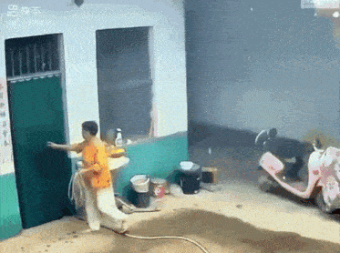 a man in an orange shirt is opening a door