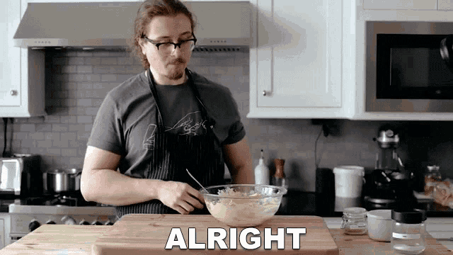 a man in an apron is preparing food in a kitchen and the word alright is on a cutting board
