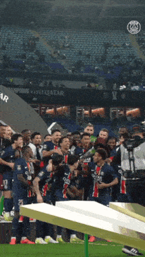 a group of soccer players wearing qatar jerseys celebrate on the field