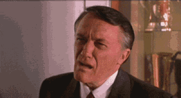 a man in a suit and tie is making a face .