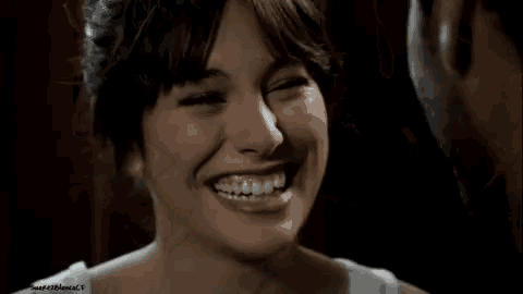 a man and a woman are looking at each other and smiling .