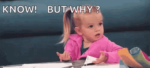 a little girl in a pink jacket is sitting at a table making a funny face and asking `` know but why ? ''