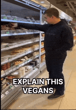 a man in a black hoodie is standing in front of a refrigerated section of a grocery store with the words explain this vegans
