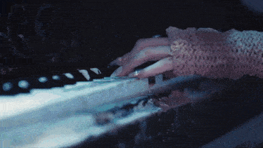 a close up of a person playing a piano in the dark