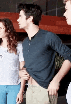 a man in a blue shirt is standing next to a woman in a white shirt