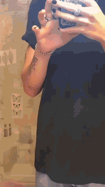 a person with a tattoo on their arm taking a selfie with a corona can