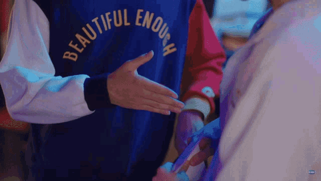 a person wearing a blue shirt that says beautiful enough on it