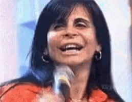 a woman is singing into a microphone while smiling .