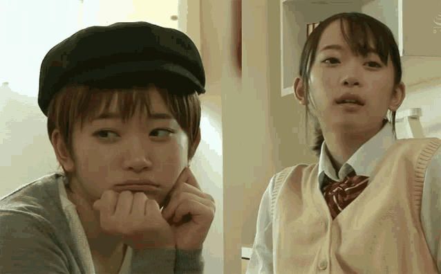a girl wearing a black hat and a girl wearing a tan vest