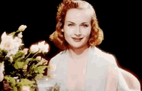 a woman is holding a bouquet of flowers in front of her face .