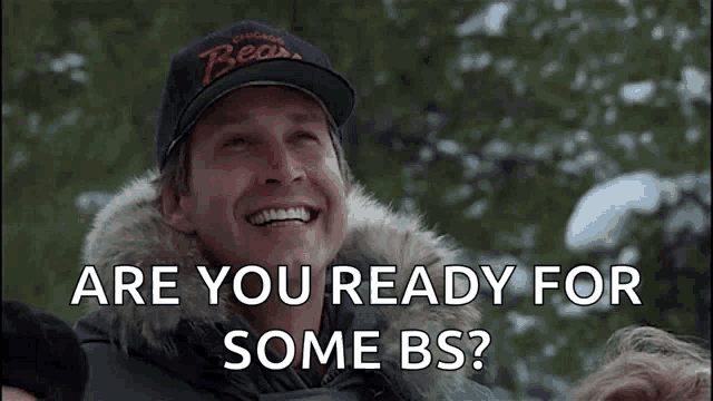 a man wearing a bears hat is smiling and says " are you ready for some bs ? "
