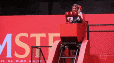 a woman is riding a roller coaster in front of a sign that says mstf .