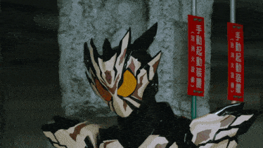a man in a mask stands in front of a sign that says " 手動 起動 装置 "