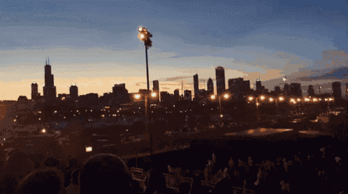 a blurry picture of a city skyline with a few lights in the foreground