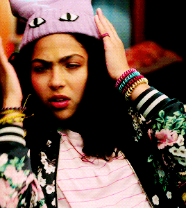 a woman wearing a floral jacket and a purple cat hat