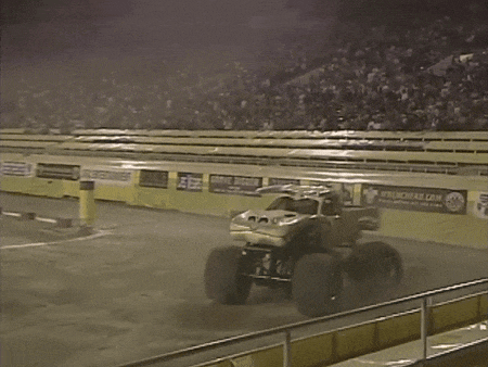 a monster truck is driving on a track with a sign that says wrenchhead.com on it