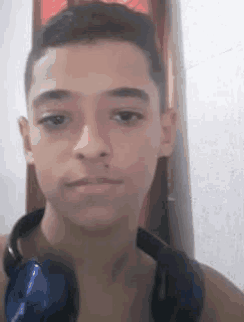 a young man wearing headphones is taking a picture of himself .