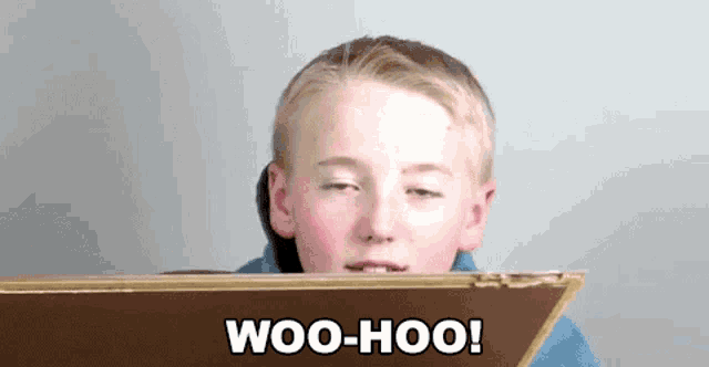 a young boy is sitting at a table with his eyes closed and the words woo-hoo written on the screen .
