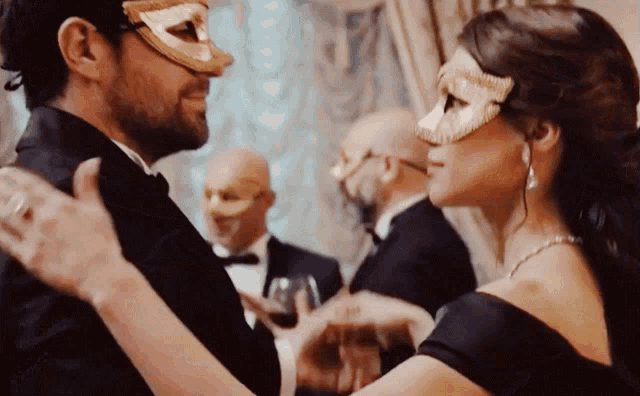 a man and a woman are wearing masks and dancing