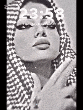 a black and white photo of a woman wearing a scarf and the time 23:58
