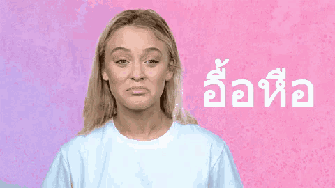 a woman in a white t-shirt is making a funny face in front of a pink background .