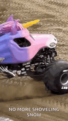 a pink and purple monster truck with a unicorn head is driving through the dirt .