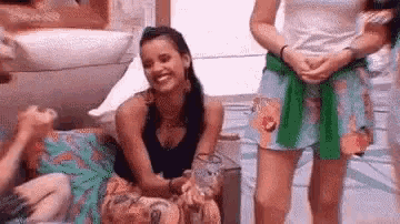 a group of women are standing next to each other and laughing in a room .