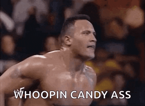 a shirtless wrestler is saying whoopin candy ass during a match .