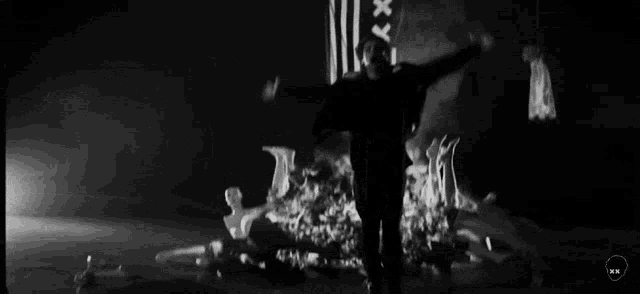 a black and white photo of a man with his arms outstretched in front of a group of people