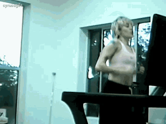 a woman is running on a treadmill in a room with the words cyrussgifs above her