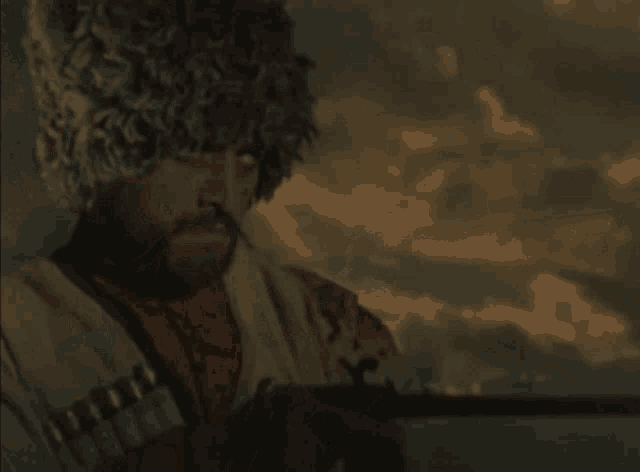 a man with a beard wearing a fur hat is holding a rifle