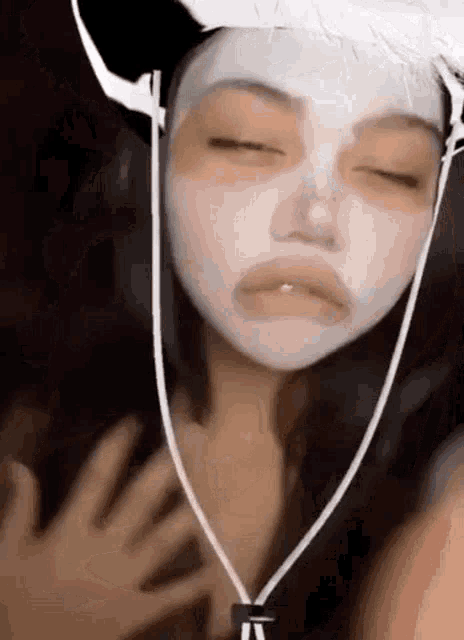 a girl wearing a cowboy hat and a white mask on her face .