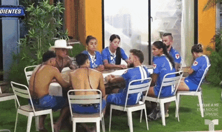 a group of people sitting around a table with a sign that says dientes